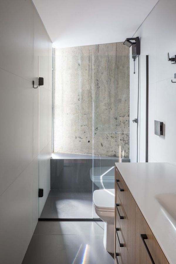 Même la salle de bain a son propre mur de béton qui est magnifiquement mis en valeur par la fenêtre