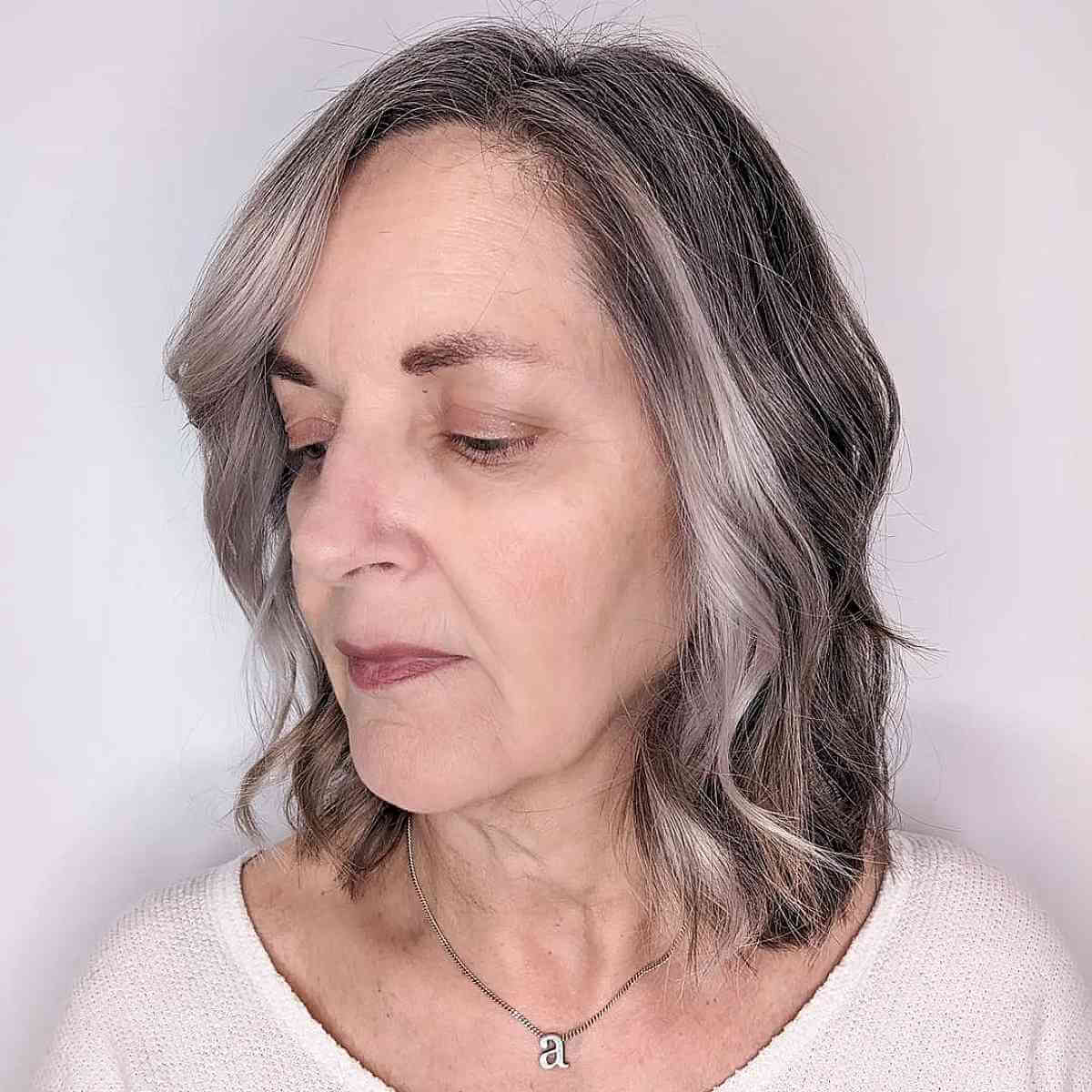 Cheveux en couches jusqu'au cou avec des vagues pour une femme de 60 ans