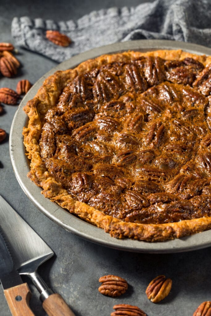 Whole Pecan Pie with Karo Syrup on a Grey Table