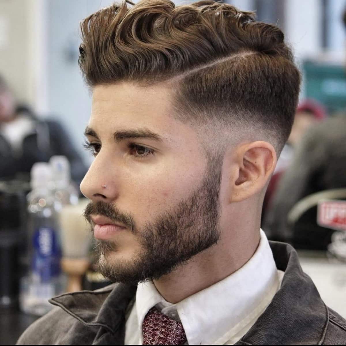 Style de séparation de côté élégant pour les hommes aux cheveux ondulés.