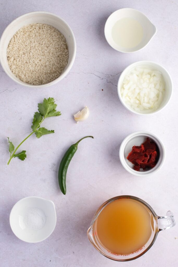 Ingrédients du riz rouge mexicain - huile végétale, riz blanc à grain long, oignon, ail, bouillon de poulet, pâte de tomate, sel, coriandre et piment