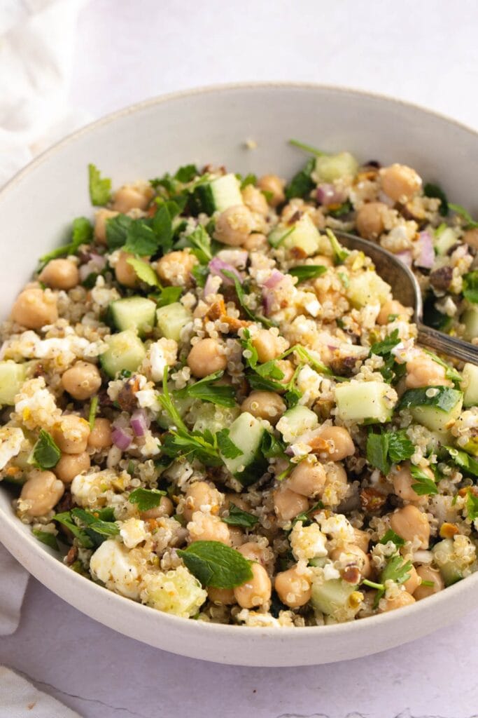 Salade saine avec quinoa, concombre, persil et oignons dans un bol blanc