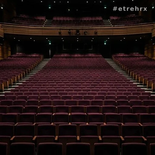 Salle de concert vide avec scène déserte, illustrant l'annulation des concerts de Patrick Bruel