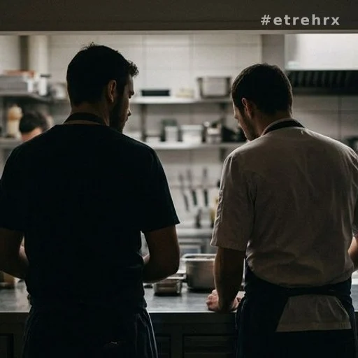 Deux silhouettes dans une cuisine professionnelle, hommage à un chef disparu
